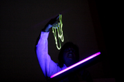 Professor Sheryl Tucker holds "glow-in-the-dark atomic worms" and demonstrates that some dye molecules impart not only color but also additional properties when interacting with light. In this case, the glow results from the molecules interacting with black light.